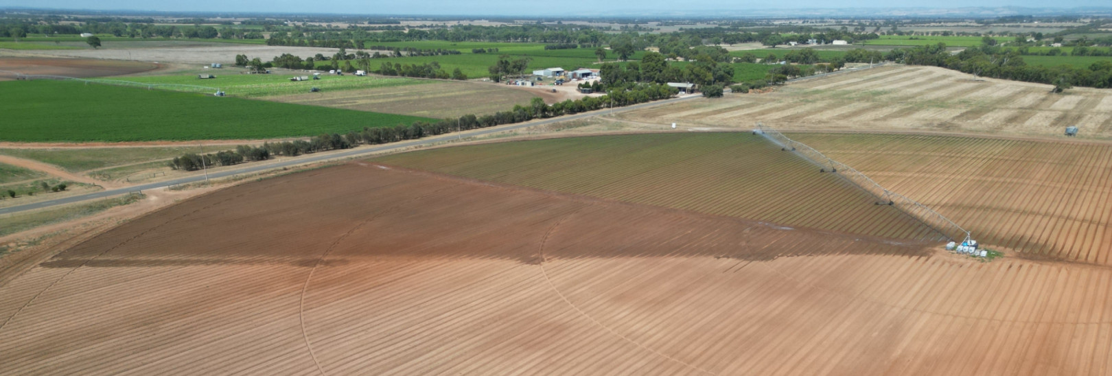 A very large, circular area of a field being watered